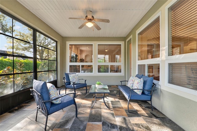 sunroom / solarium featuring a ceiling fan, plenty of natural light, and wood ceiling