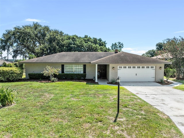 single story home with brick siding, an attached garage, driveway, and a front yard