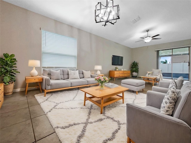 living area with visible vents, ceiling fan with notable chandelier, and baseboards