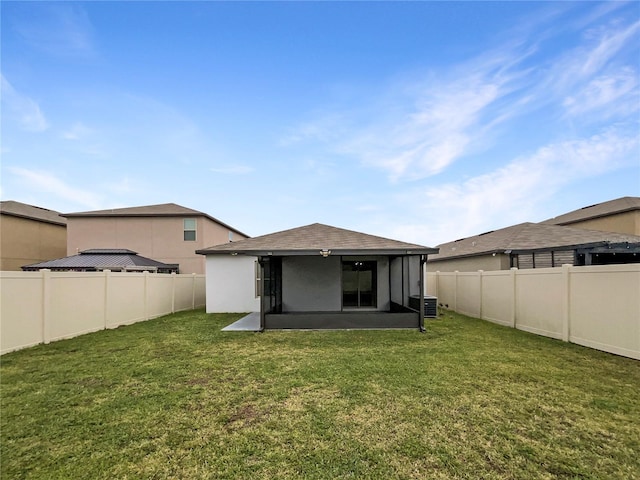 rear view of property with a lawn, central AC, a fenced backyard, and stucco siding