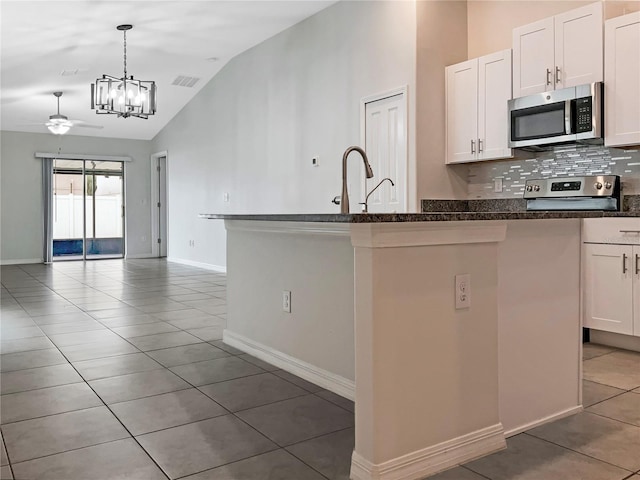 kitchen with visible vents, decorative backsplash, vaulted ceiling, appliances with stainless steel finishes, and open floor plan