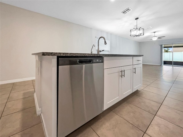 kitchen with light tile patterned floors, a sink, white cabinets, and stainless steel dishwasher