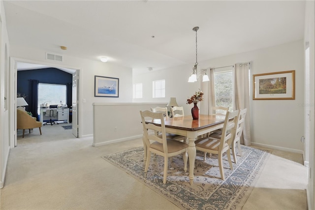 dining room featuring an inviting chandelier, plenty of natural light, visible vents, and light carpet