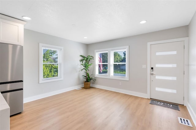 entryway featuring a healthy amount of sunlight, visible vents, and baseboards