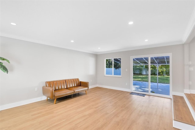 living area featuring crown molding, recessed lighting, baseboards, and light wood finished floors