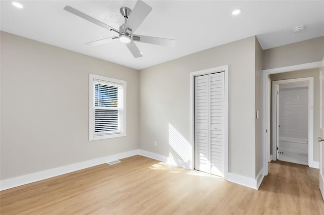 unfurnished bedroom featuring a closet, baseboards, visible vents, and light wood-style flooring