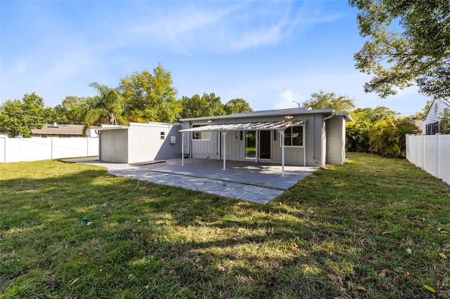 rear view of house featuring a yard, a patio, board and batten siding, and a fenced backyard