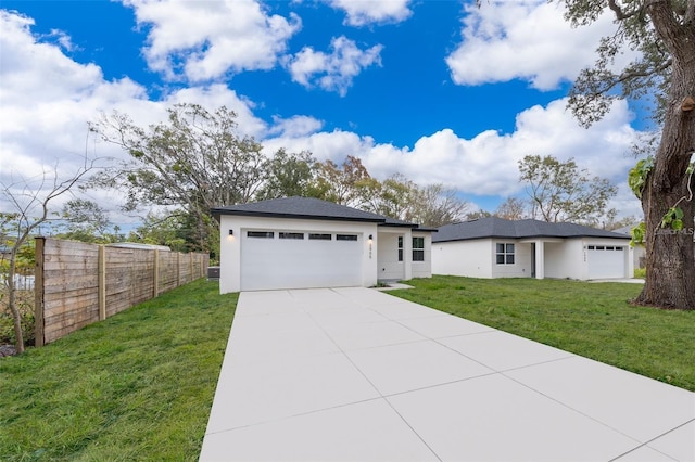 view of front of home featuring stucco siding, a front lawn, driveway, fence, and a garage