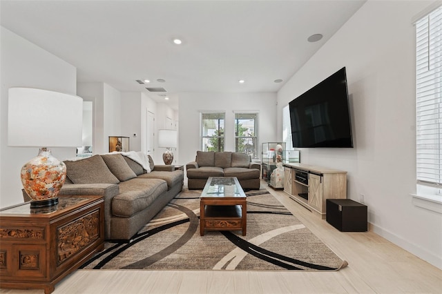 living area with recessed lighting, visible vents, and baseboards