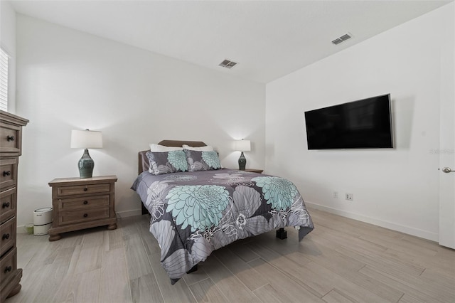 bedroom with visible vents, baseboards, and light wood-style flooring