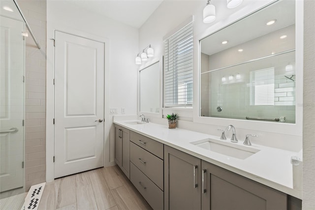 full bathroom with double vanity, a stall shower, and a sink