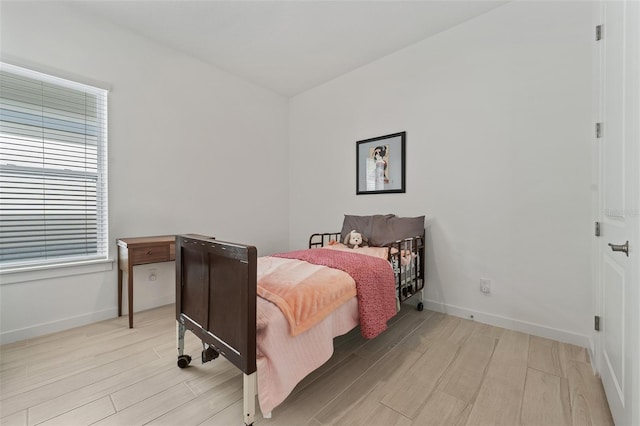 bedroom featuring baseboards and light wood-style flooring