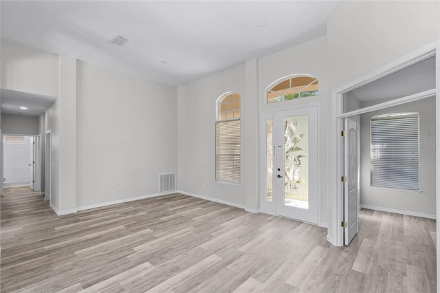 entrance foyer with light wood-style floors, visible vents, and a wealth of natural light