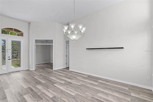 unfurnished dining area with an inviting chandelier, light wood-style flooring, and baseboards