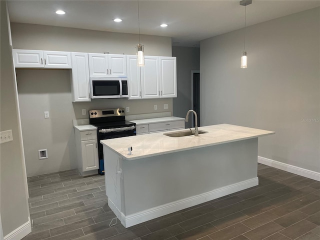 kitchen with a sink, white cabinetry, recessed lighting, stainless steel appliances, and wood tiled floor