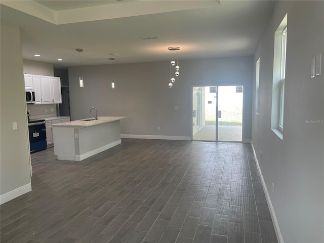 kitchen with dark wood-type flooring, baseboards, electric range, white cabinetry, and a sink