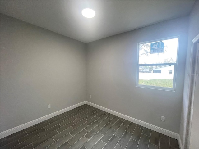 empty room with dark wood-style floors and baseboards