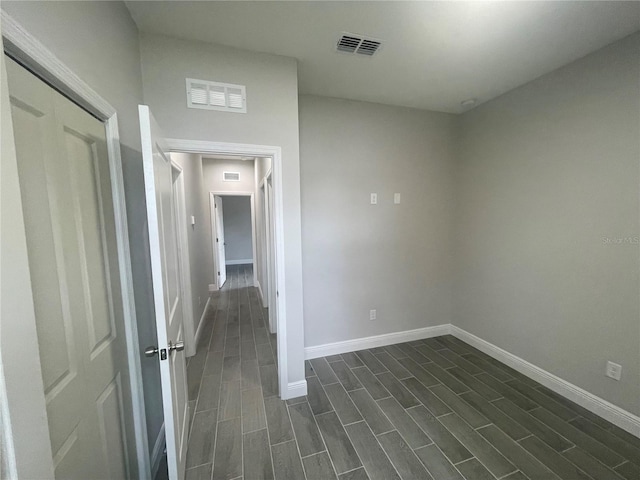 spare room featuring visible vents, baseboards, and wood finish floors