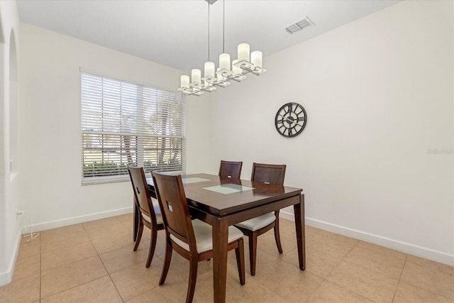 dining room with light tile patterned floors, visible vents, baseboards, and a notable chandelier