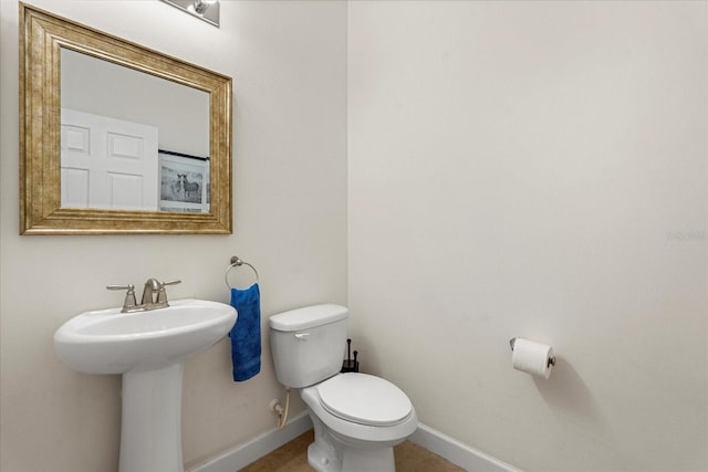 half bathroom with toilet and baseboards