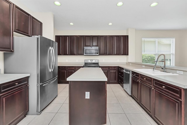 kitchen featuring a sink, a kitchen island, stainless steel appliances, light tile patterned flooring, and light countertops