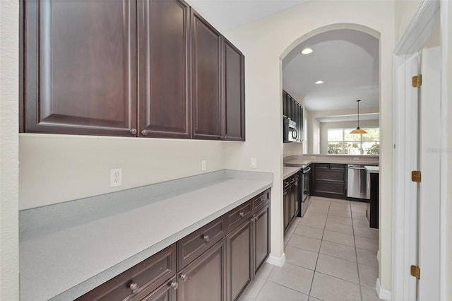 kitchen with light tile patterned floors, recessed lighting, arched walkways, stainless steel appliances, and light countertops