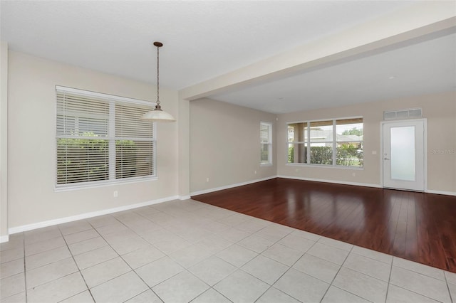 unfurnished room featuring visible vents, baseboards, and light wood finished floors