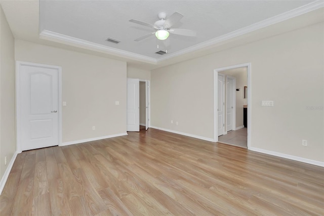 spare room featuring visible vents, light wood-style flooring, a ceiling fan, and ornamental molding