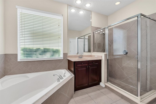 bathroom featuring a stall shower, recessed lighting, tile patterned flooring, a bath, and vanity