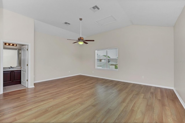 interior space featuring lofted ceiling, baseboards, visible vents, and light wood-type flooring