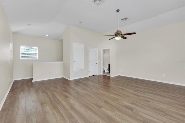 unfurnished living room featuring lofted ceiling, light wood-style floors, visible vents, and baseboards