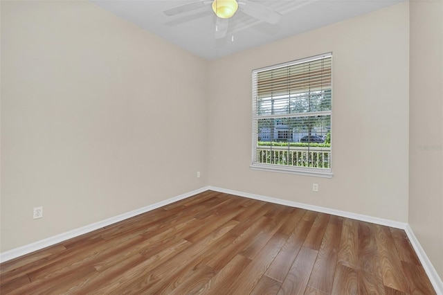 unfurnished room featuring ceiling fan, baseboards, and wood finished floors