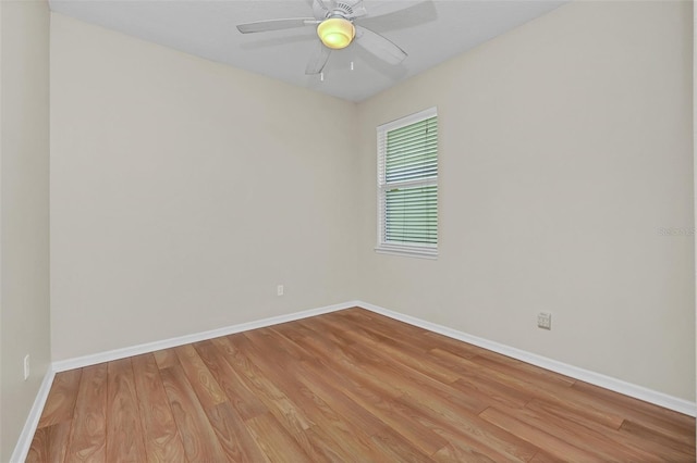 spare room with wood finished floors, baseboards, and ceiling fan