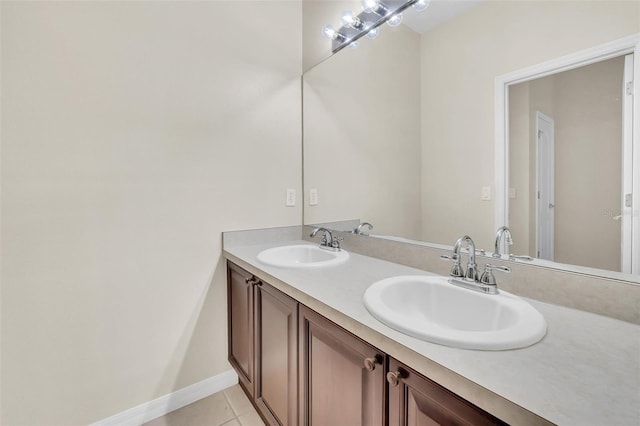 bathroom with tile patterned floors, double vanity, baseboards, and a sink