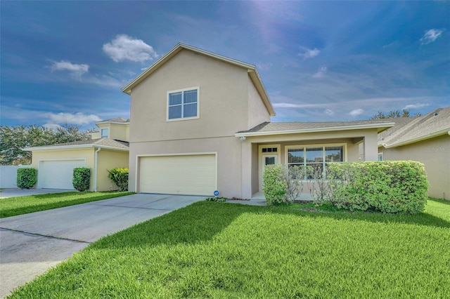 traditional-style house featuring stucco siding, driveway, an attached garage, and a front yard