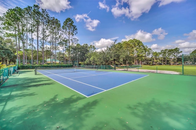 view of tennis court featuring fence