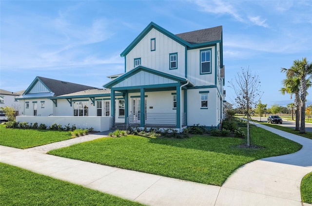 view of front of property featuring a porch, board and batten siding, and a front lawn