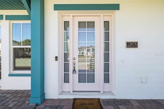 doorway to property featuring stucco siding