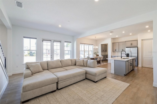 living area featuring recessed lighting, visible vents, light wood-style flooring, and baseboards