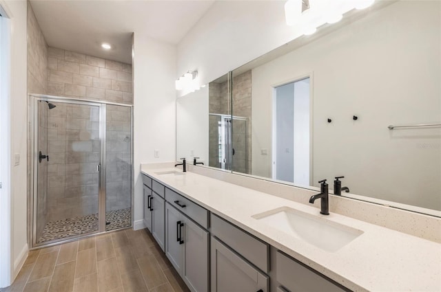 bathroom with a sink, double vanity, and a shower stall