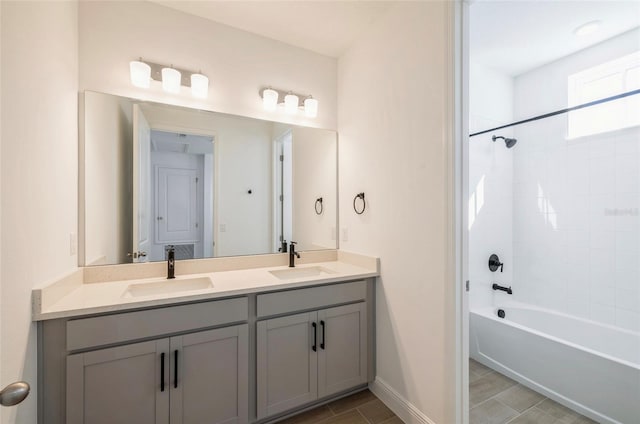 full bath featuring double vanity, shower / bathtub combination, baseboards, and a sink