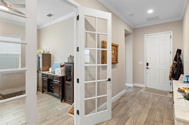 hall featuring light wood-type flooring, visible vents, and ornamental molding