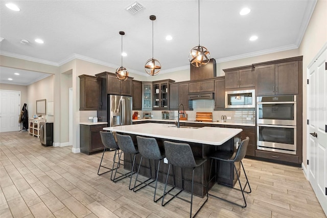 kitchen featuring visible vents, a sink, stainless steel appliances, light countertops, and dark brown cabinets