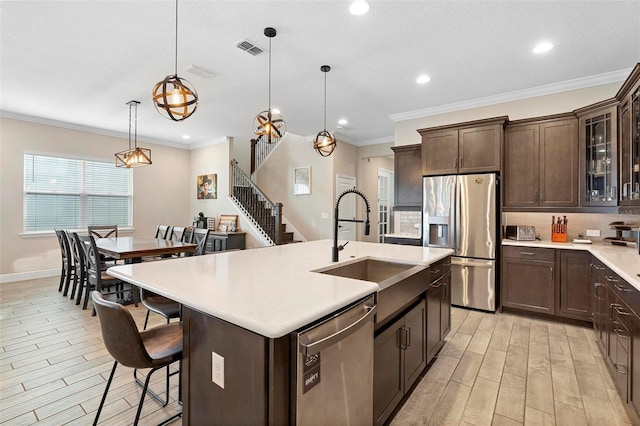 kitchen featuring visible vents, wood tiled floor, light countertops, dark brown cabinets, and appliances with stainless steel finishes