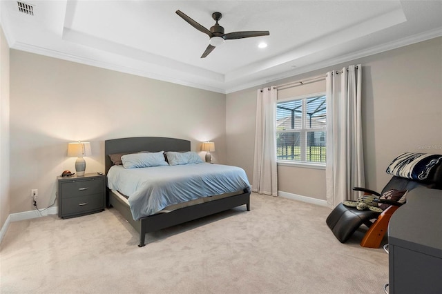 bedroom with visible vents, light colored carpet, a raised ceiling, and baseboards