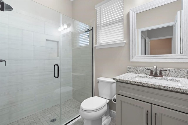 bathroom featuring vanity, toilet, and a stall shower