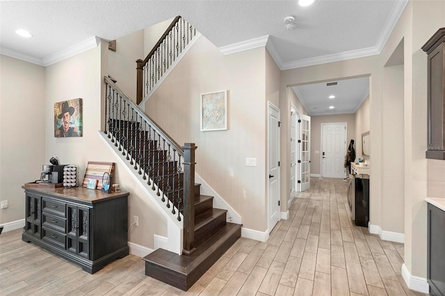 entryway featuring baseboards, light wood-style flooring, and ornamental molding