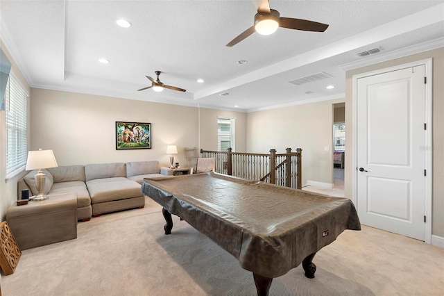 recreation room featuring a tray ceiling, crown molding, visible vents, and light carpet