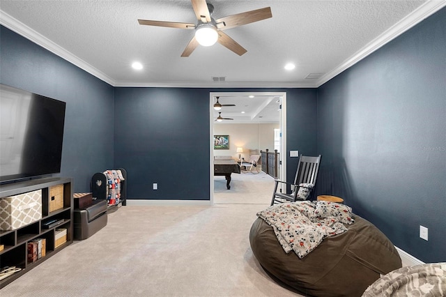 sitting room with a textured ceiling, carpet flooring, baseboards, and ornamental molding