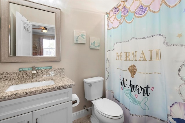 bathroom with vanity, a shower with shower curtain, toilet, and baseboards